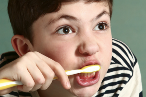 bērns, kas intensīvi tīra zobus
